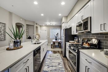 an open kitchen with white cabinets and stainless steel appliances